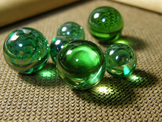 green glass balls sitting on top of a couch