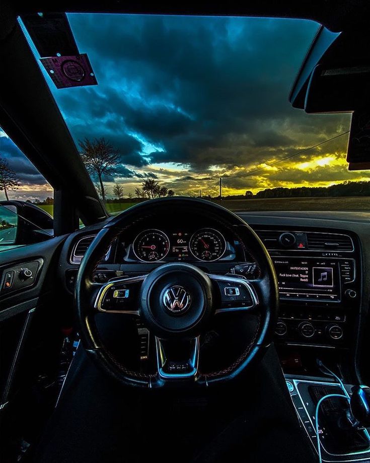 the interior of a car with dashboard lights on and steering wheel in front of it