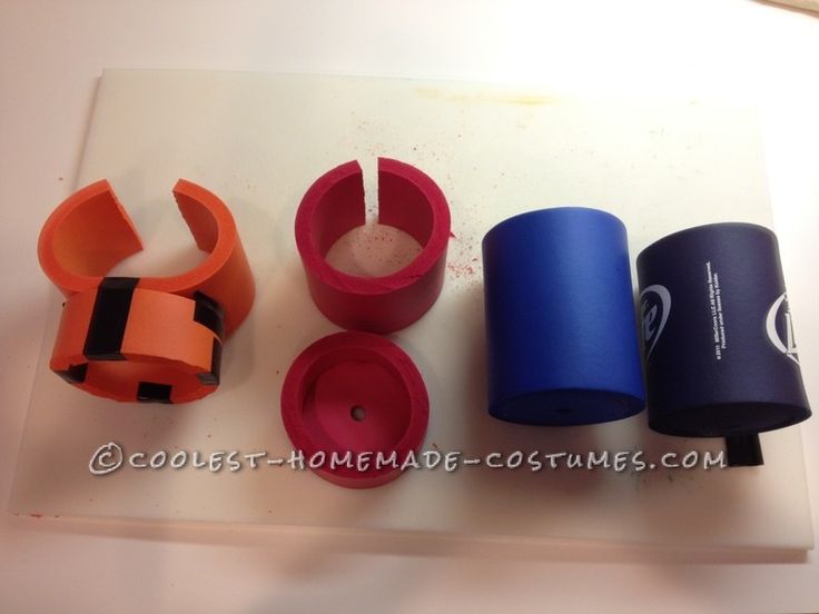 four different colored cups sitting on top of a cutting board