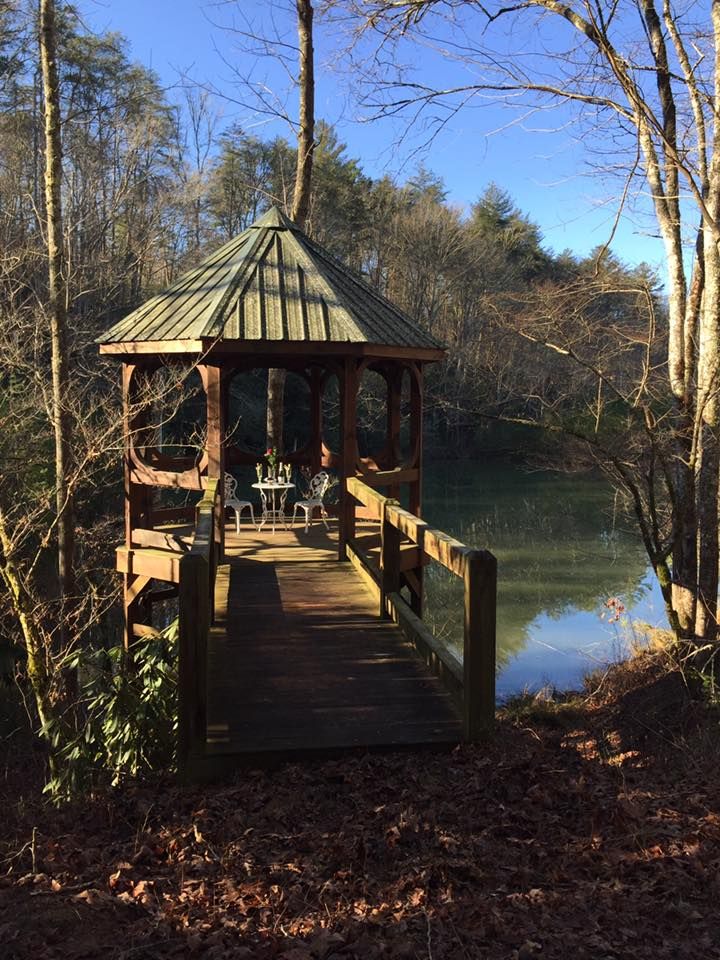 a gazebo sitting on top of a wooden bridge