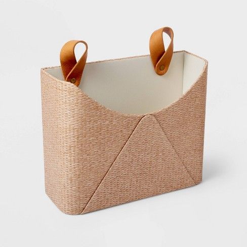 a basket with two handles is shown on a white surface and it has brown leather handles