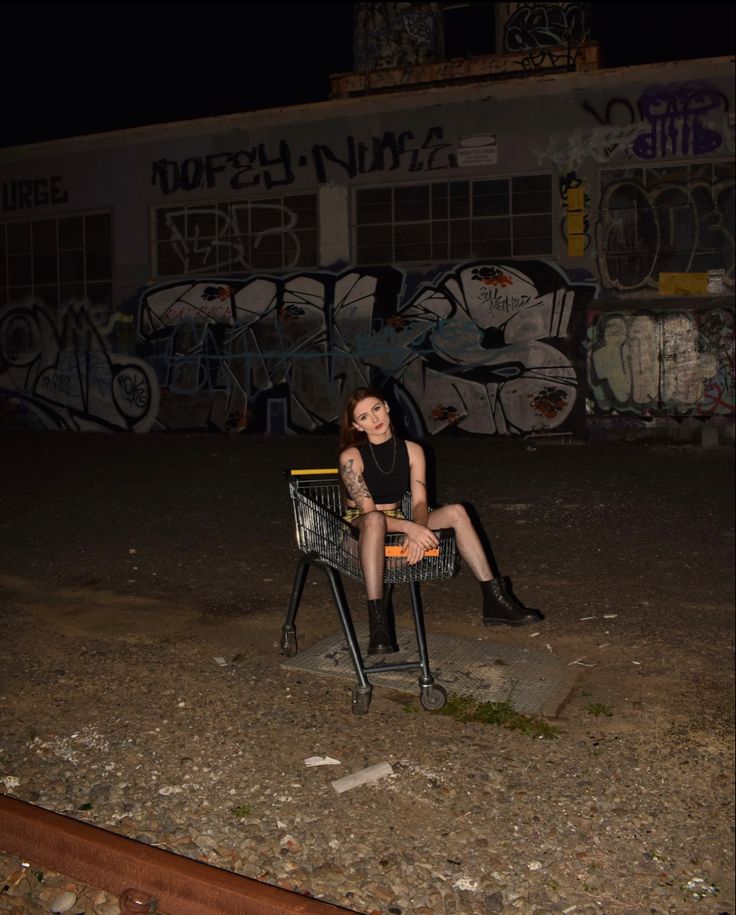 a woman sitting in a chair with graffiti on the wall behind her