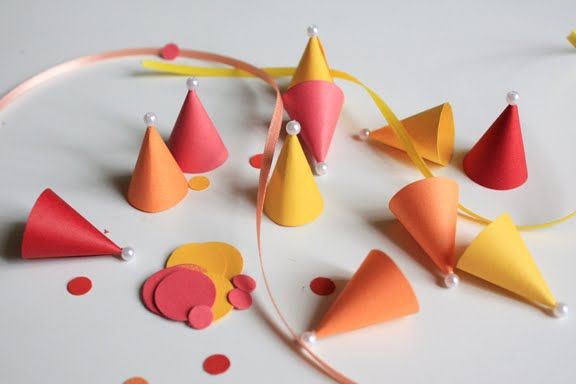 colorful party hats and streamers on a white table