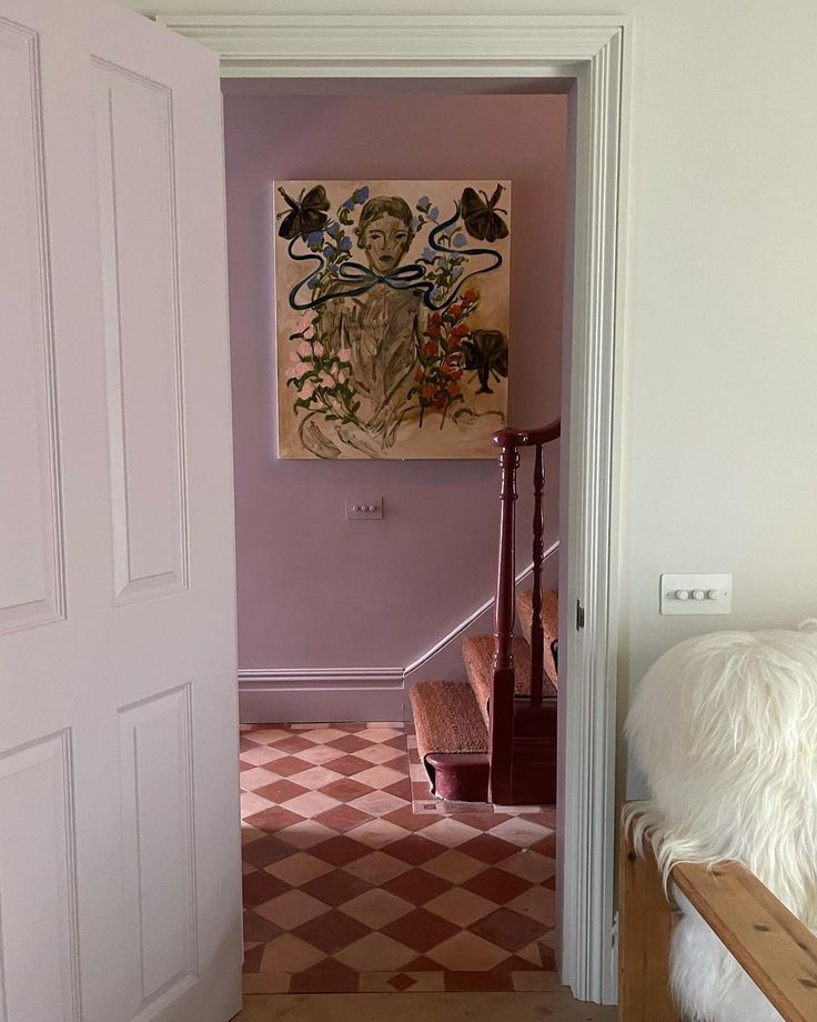 an open door leading to a bedroom with pink walls and checkered flooring in the hallway