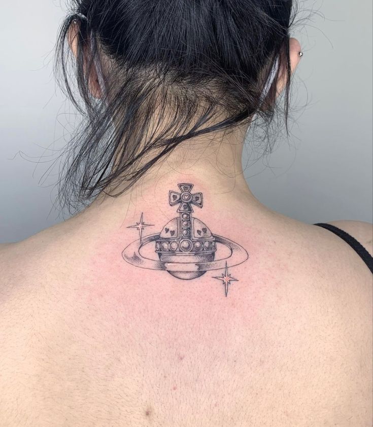 the back of a woman's neck with an anchor and cross tattoo on it