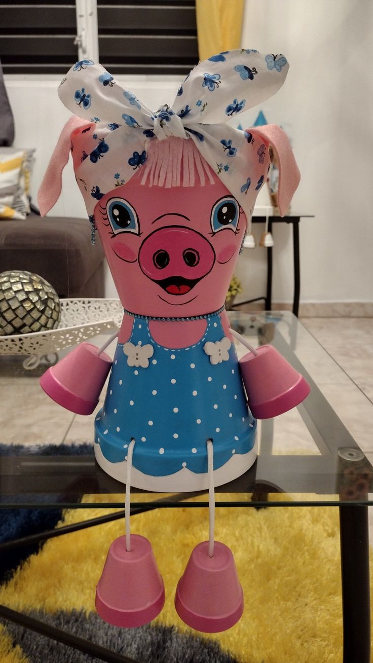 a pink pig sitting on top of a glass table