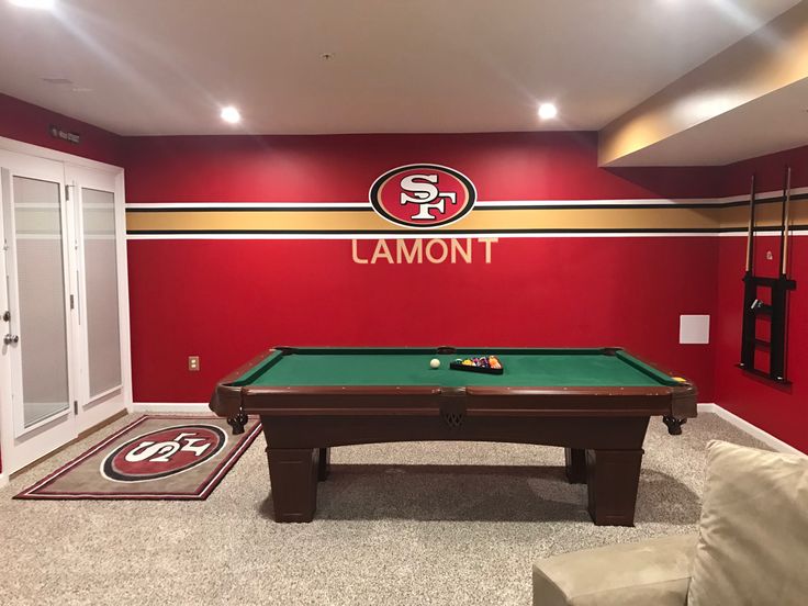 a room with a pool table in the middle and a carpet on the floor next to it