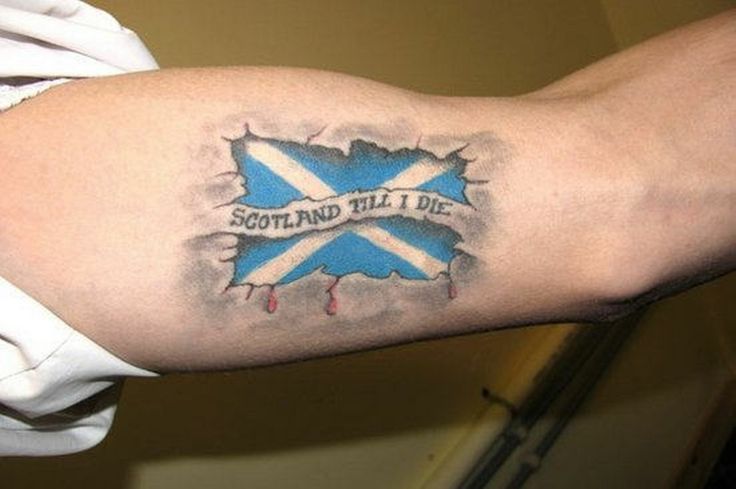 a man with a scottish flag tattoo on his arm holding onto a white shirt that says scotland till die