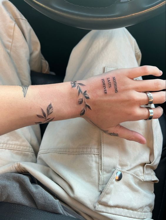 a woman's hand with a tattoo on it, sitting in a car seat