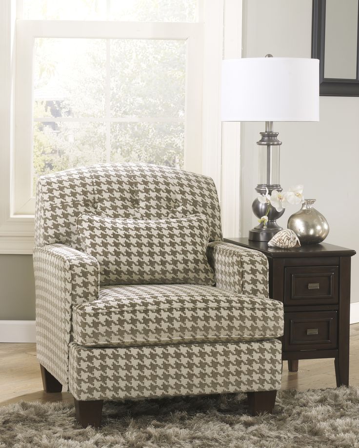 a brown and white chair sitting on top of a rug