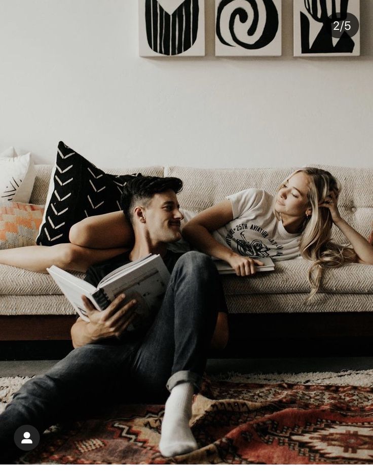 a man and woman are laying on a couch