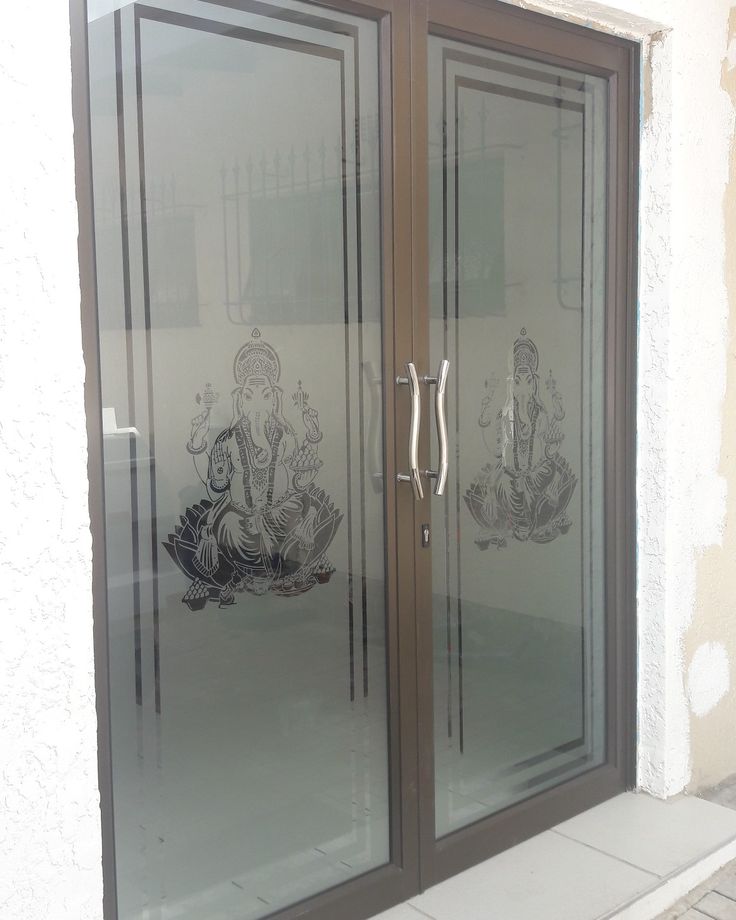 the glass doors are decorated with an image of ganesh and buddhas on them