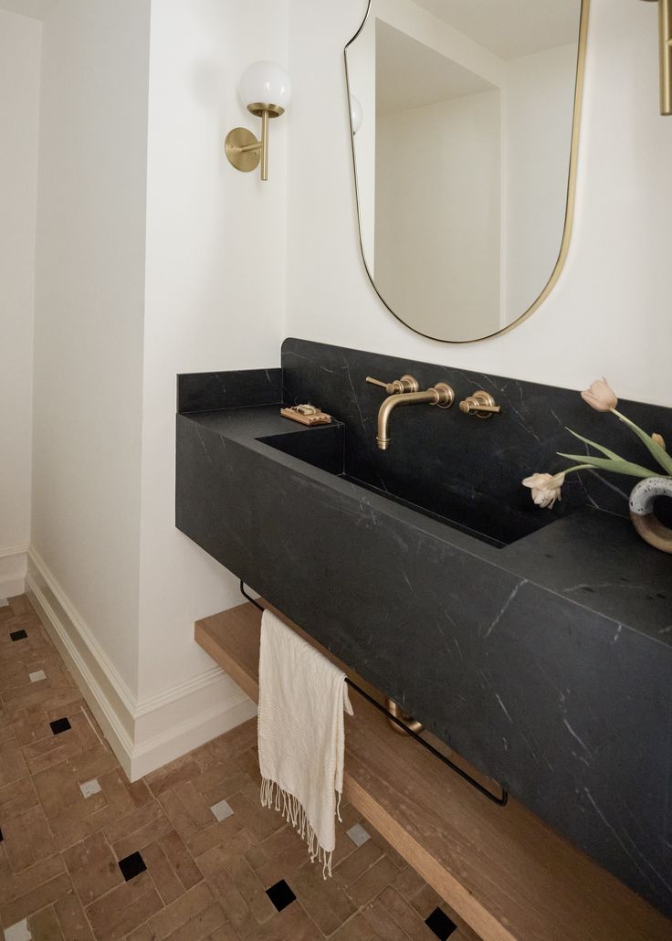 a bathroom with two sinks and a mirror on the wall next to it is tiled flooring