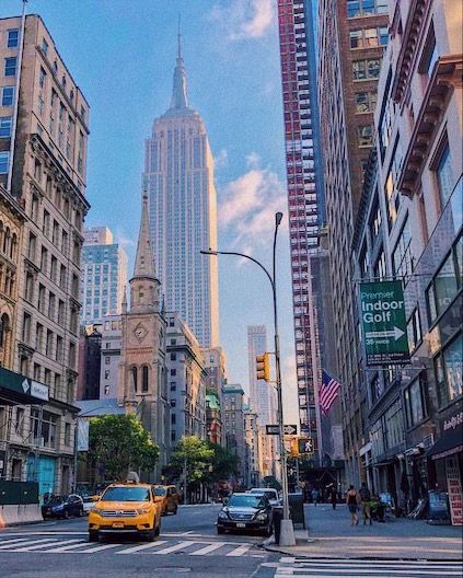 a city street with tall buildings in the background