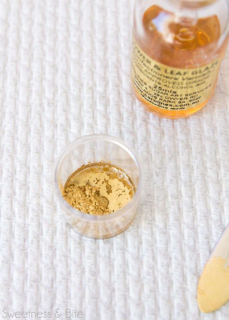 an open jar of mustard next to a spoon on a white tablecloth with a wooden spoon