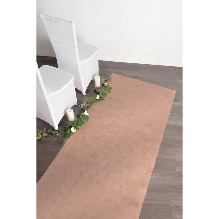 two white chairs sitting on top of a wooden floor next to a rug with greenery