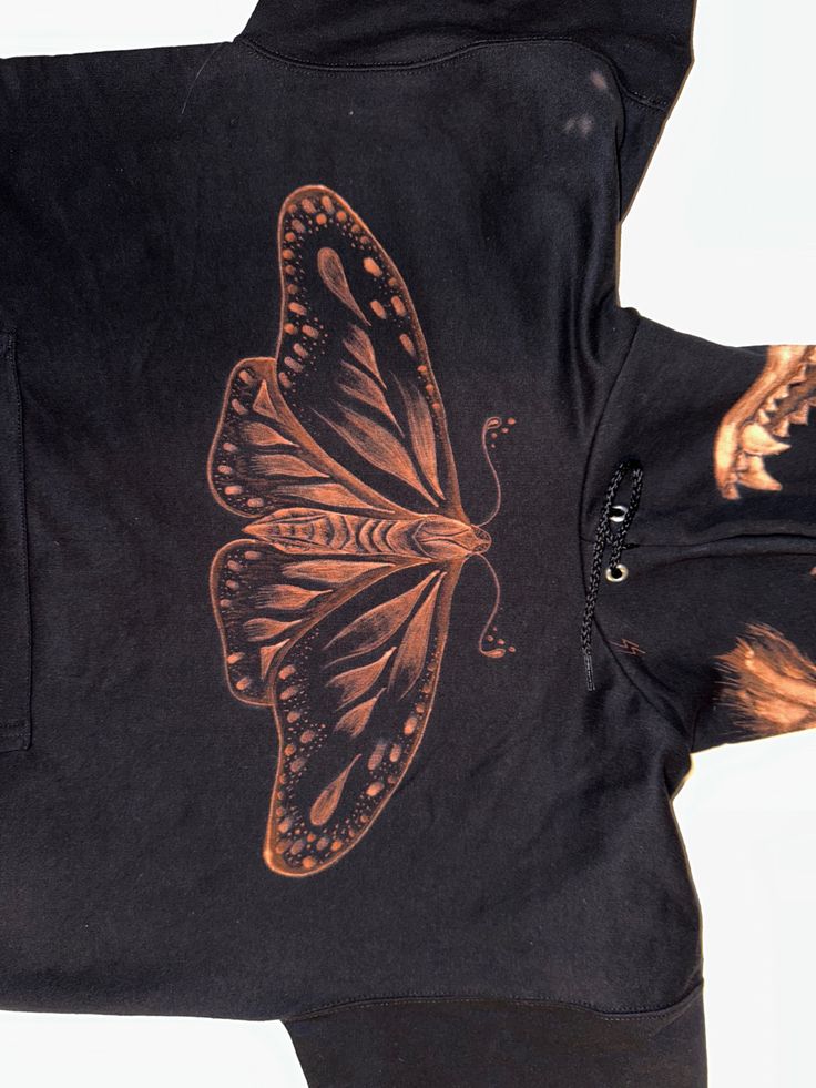 an image of a butterfly on a black hoodie that is worn by someone else