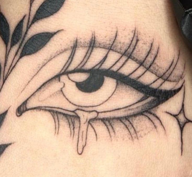 a close up view of an eye with leaves on it's side tattoo design