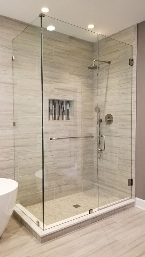 a bathroom with a glass shower door next to a bathtub