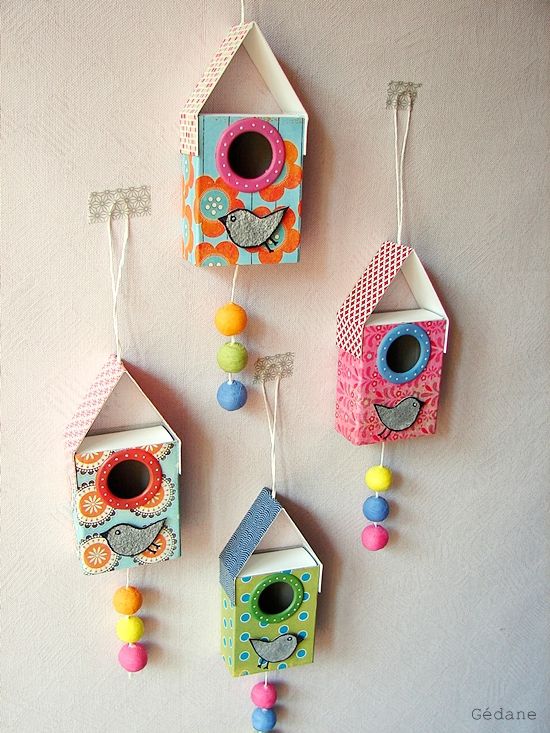 three colorful birdhouses hanging on the wall