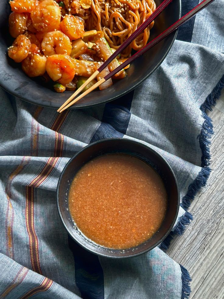 two bowls filled with food and chopsticks on top of a table next to each other