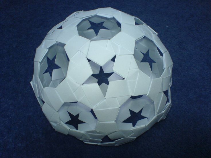 an origami soccer ball with blue stars on the top and bottom, sitting on a black surface