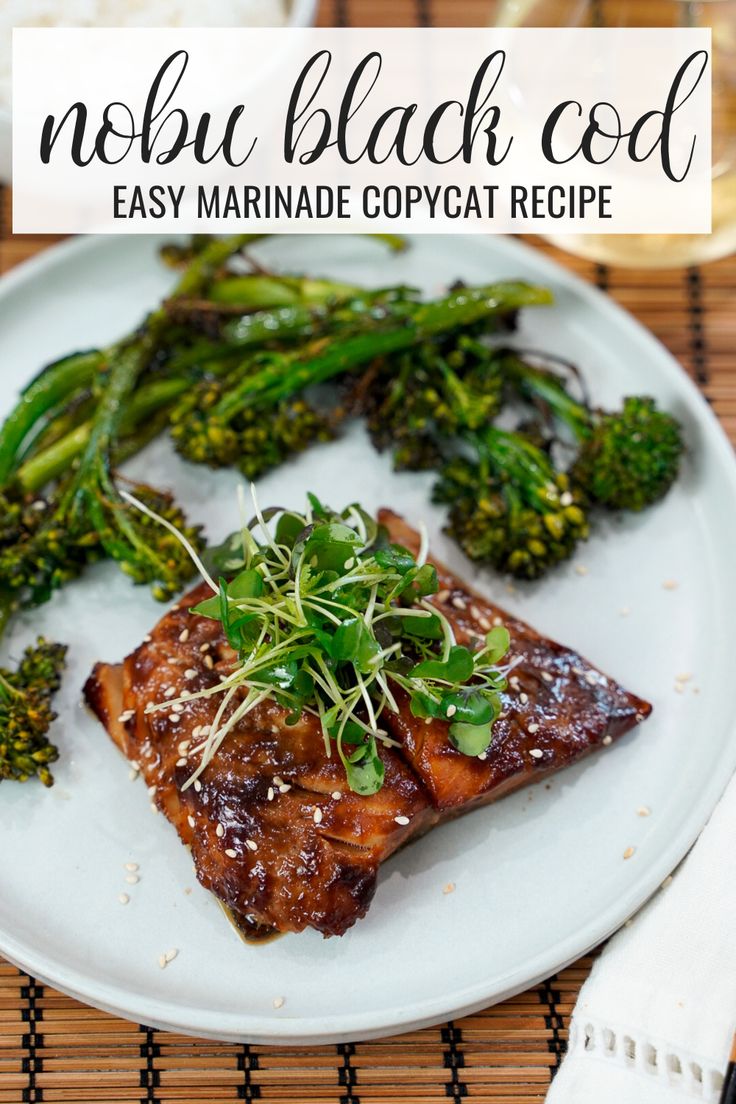 a white plate topped with meat and broccoli on top of a bamboo mat