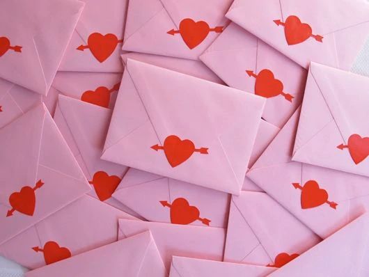 many pink envelopes with red hearts on them