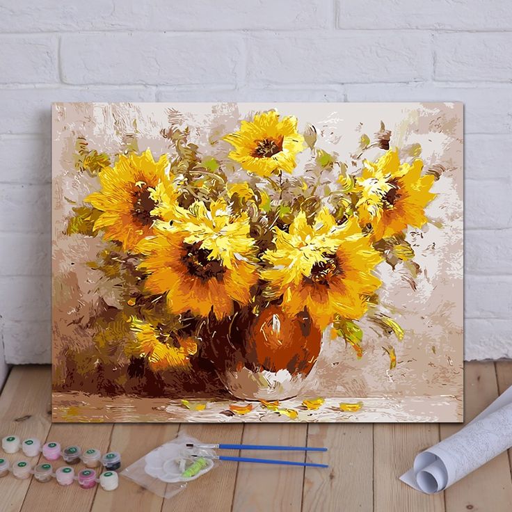 a painting of sunflowers in a vase on a table with paintbrushes