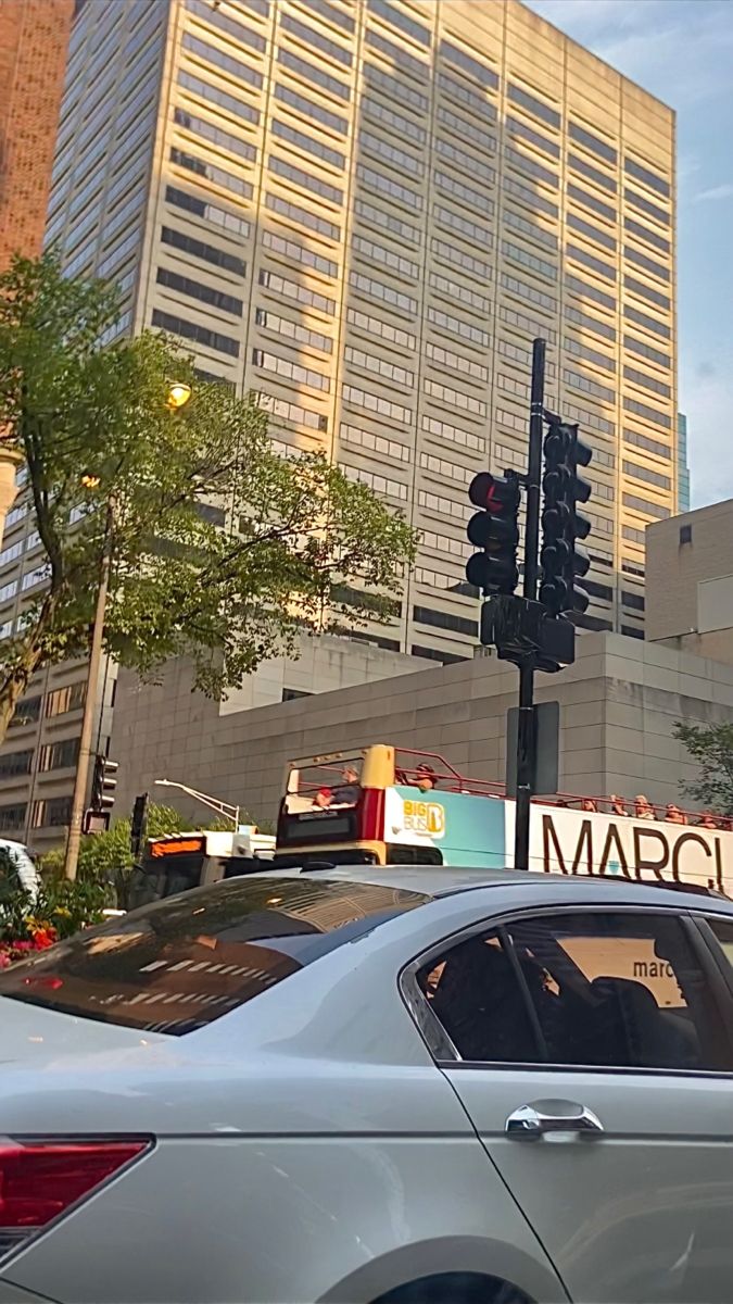 a car stopped at a traffic light in front of a large building with a marquee sign on it