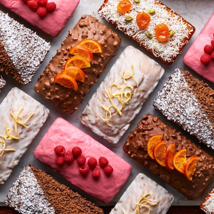 there are many different types of desserts on the table together, including oranges and raspberries