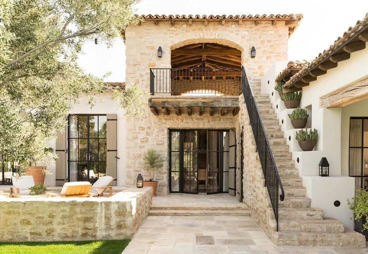 an outside view of a house with stairs leading up to the front door and patio