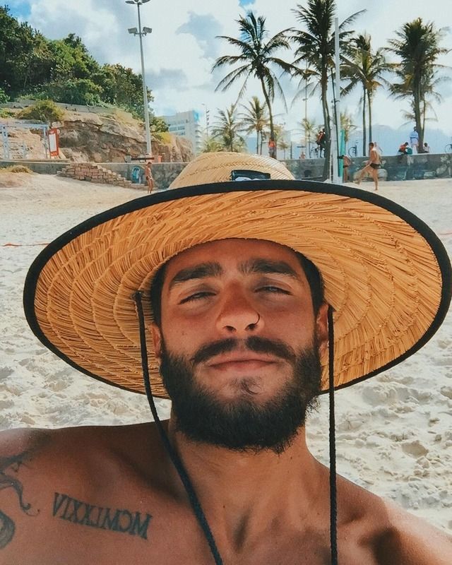 a man wearing a straw hat on the beach