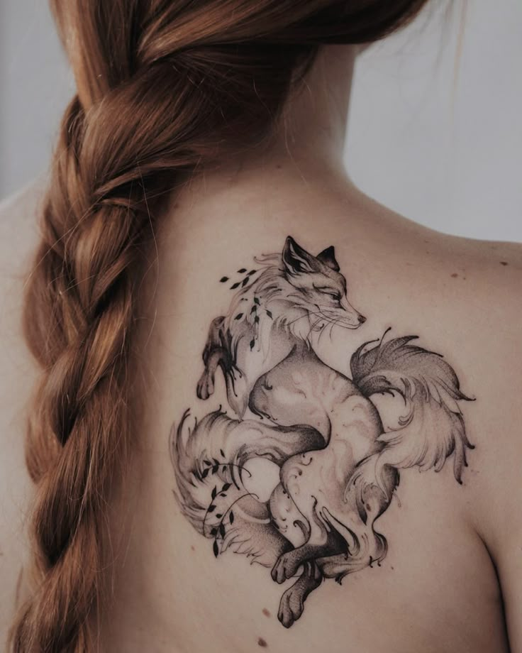 a woman with a tattoo on her back that has two wolfs in the middle