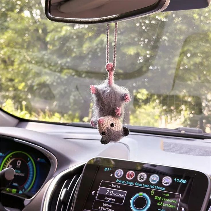 a stuffed animal hanging from the dashboard of a car