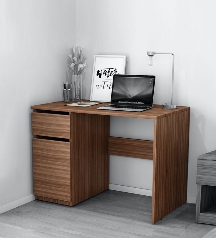 a laptop computer sitting on top of a wooden desk next to a vase with flowers