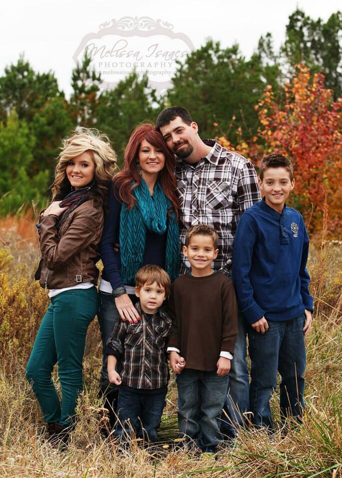 a family posing for a photo in the grass