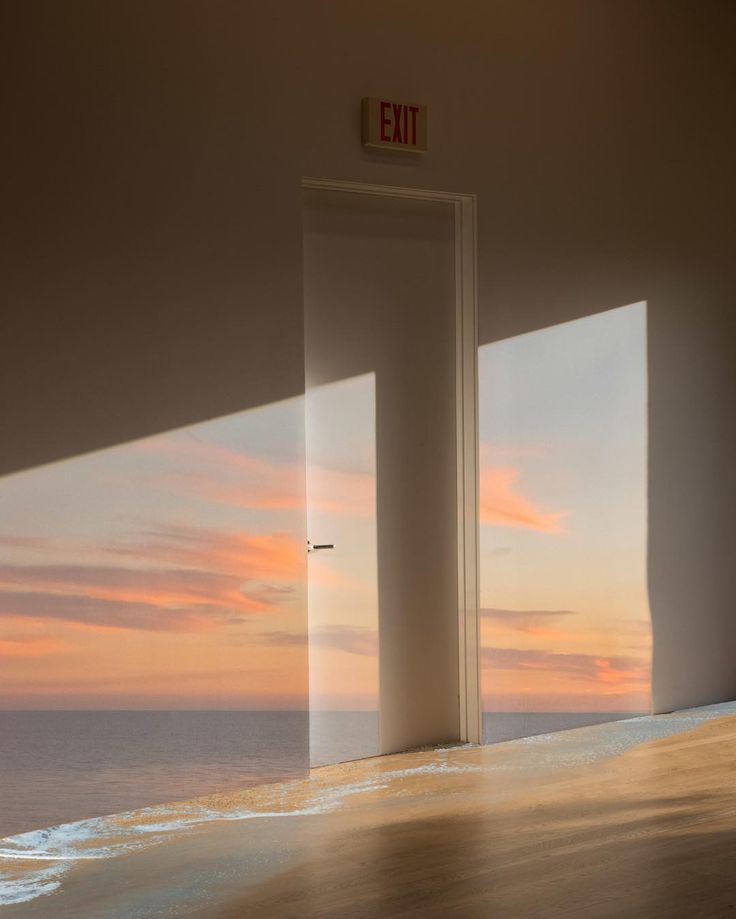 an open door leading to the ocean at sunset