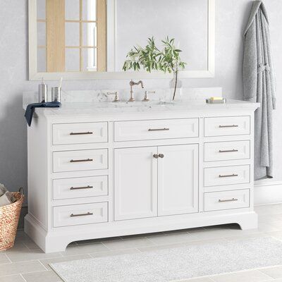 a white bathroom vanity with two mirrors above it and a plant on the counter top