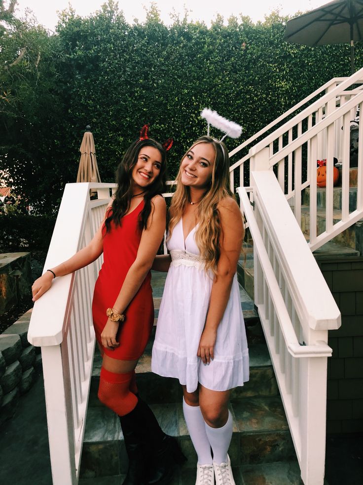 two women standing next to each other in front of some white railings and stairs