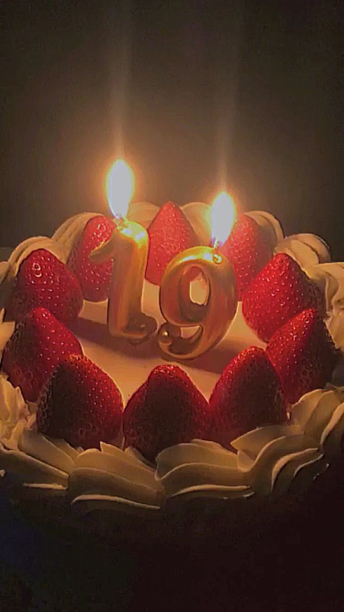 a birthday cake with candles and strawberries in the shape of number 19 on it