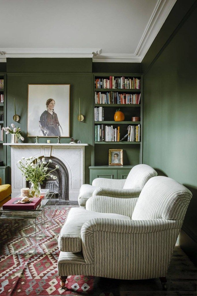 a living room filled with furniture and a fire place in front of a book shelf