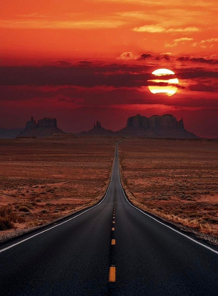 the sun is setting over an empty road in the middle of nowhere with no cars on it