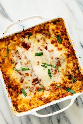 a casserole dish with meat and cheese in it on a marble countertop