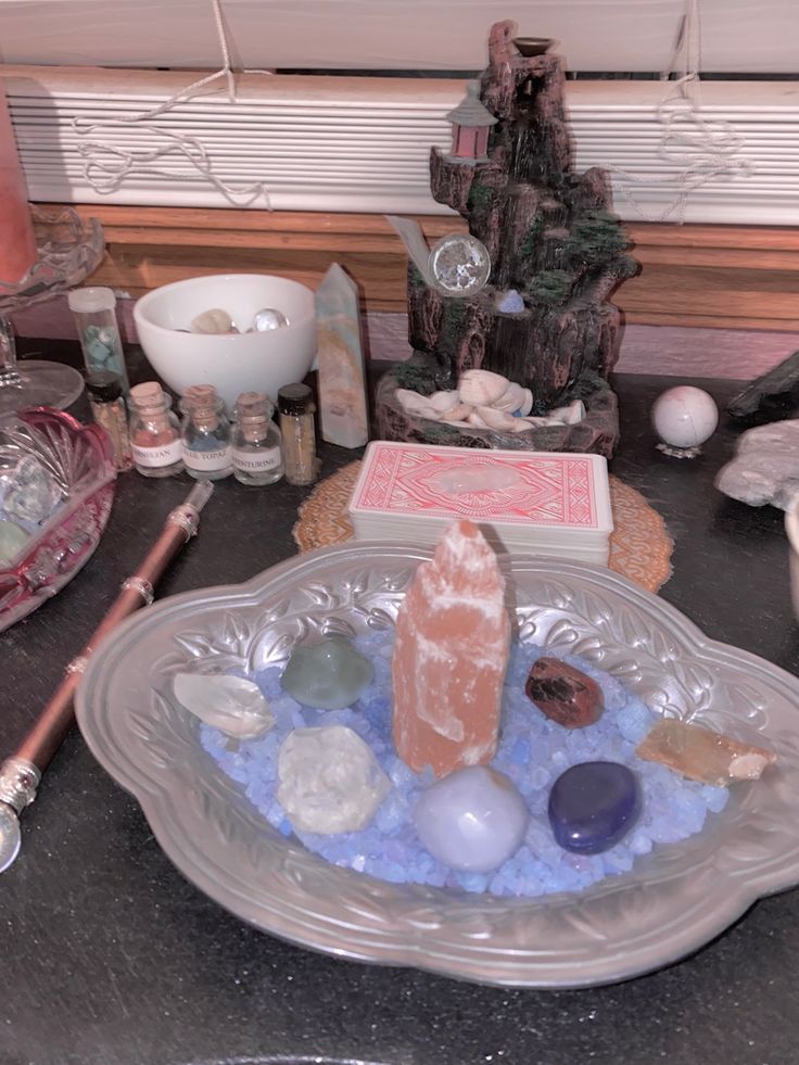 an assortment of rocks and crystals on a glass plate in front of a window sill