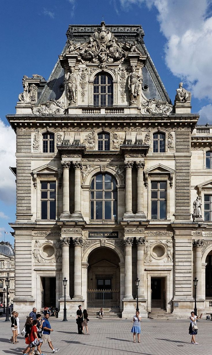 people are walking around in front of an old building