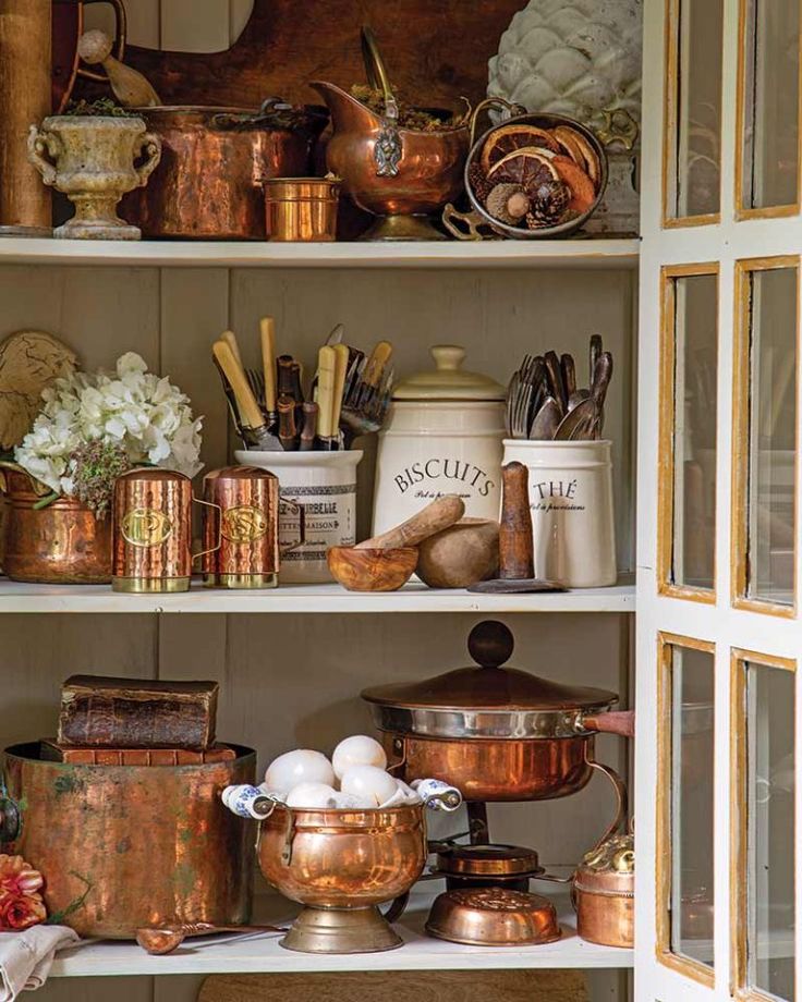 the shelves are filled with copper pots and pans