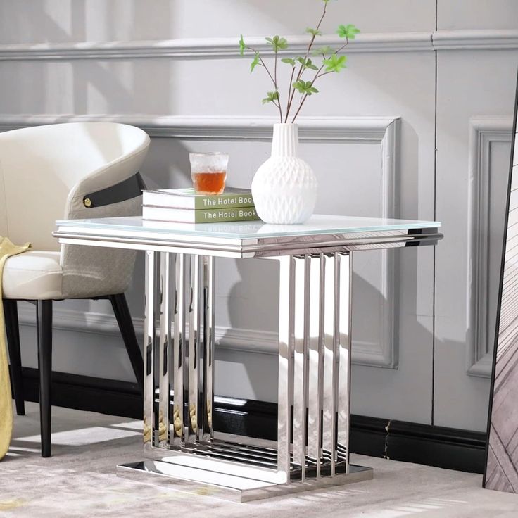 a glass table with some books and a vase on it