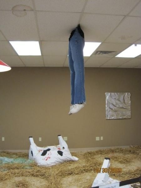 an upside down bag is on the ground in front of a pair of jeans hanging from a ceiling