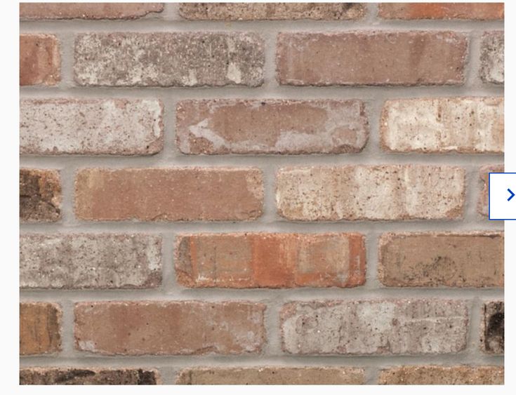 a red fire hydrant sitting on the side of a brick wall